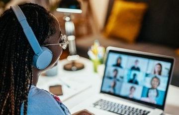 Woman at laptop on zoom call with nine people