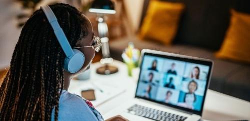 Woman at laptop on zoom call with nine people